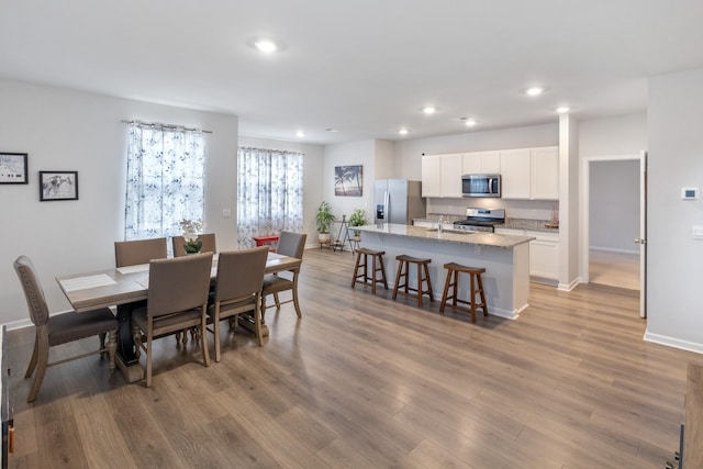 dining area featuring recessed lighting, wood finished floors, and baseboards