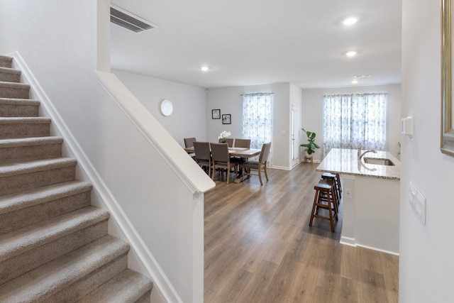 stairs featuring visible vents, recessed lighting, baseboards, and wood finished floors