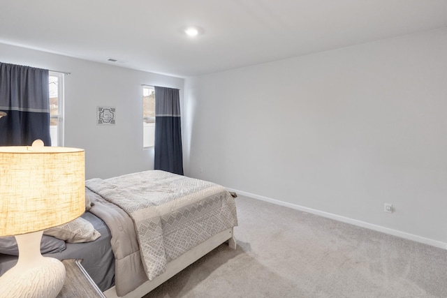 bedroom featuring visible vents, baseboards, and carpet