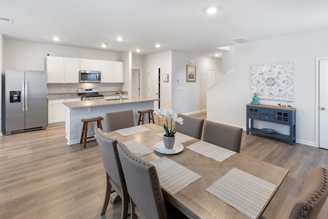 dining room with recessed lighting, visible vents, baseboards, and light wood-style floors