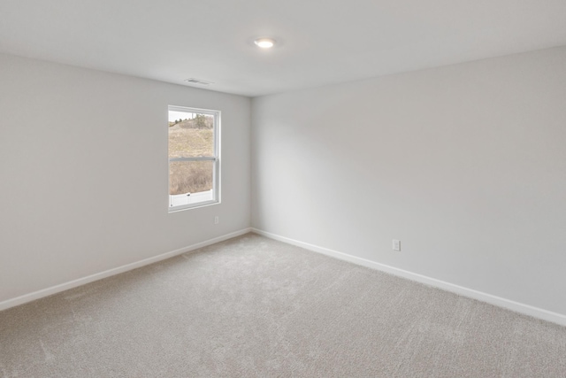 spare room with baseboards, visible vents, and carpet floors