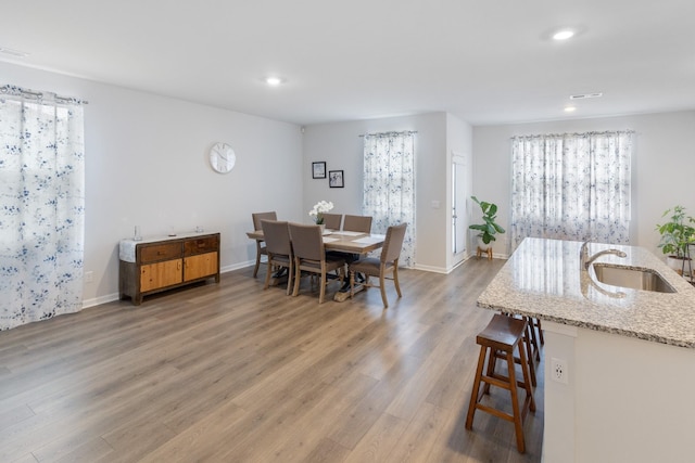 dining area with recessed lighting, light wood-type flooring, and baseboards