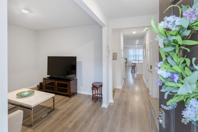 living room featuring light wood-style flooring, recessed lighting, and baseboards