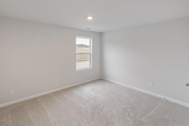 carpeted spare room with baseboards