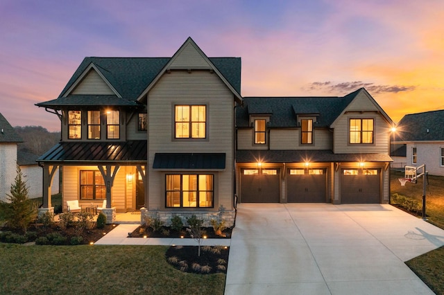 view of front of home with a standing seam roof, a porch, an attached garage, concrete driveway, and metal roof