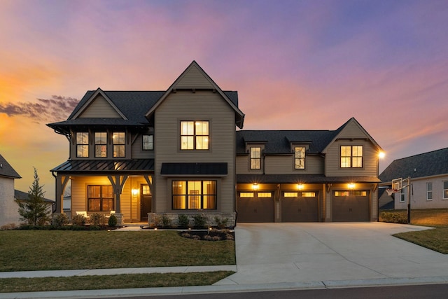 modern farmhouse style home featuring a front yard, a standing seam roof, concrete driveway, a garage, and metal roof