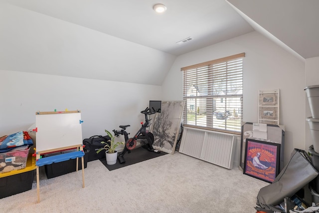 workout area with visible vents, lofted ceiling, radiator, and carpet floors