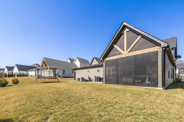 rear view of house featuring a yard, central AC, and a sunroom