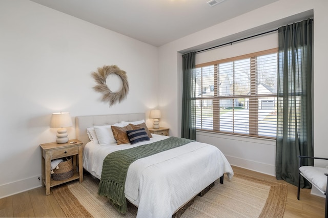 bedroom featuring visible vents, wood finished floors, and baseboards