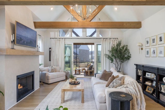 living room with lofted ceiling with beams, recessed lighting, a warm lit fireplace, an inviting chandelier, and wood finished floors