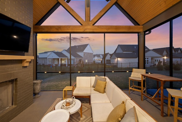 sunroom / solarium featuring a wealth of natural light, a residential view, lofted ceiling, and an outdoor brick fireplace