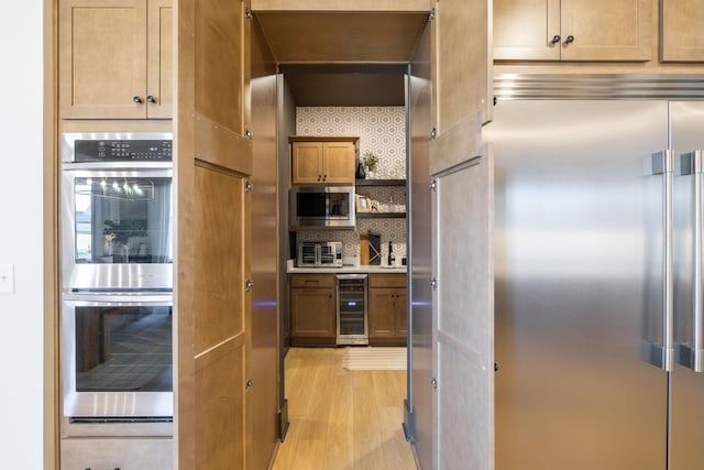 kitchen featuring beverage cooler, open shelves, decorative backsplash, light wood-style floors, and built in appliances