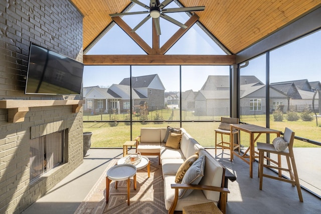 sunroom / solarium featuring ceiling fan, an outdoor brick fireplace, a residential view, vaulted ceiling, and wooden ceiling