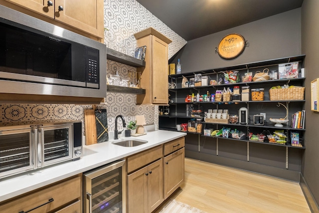 kitchen featuring beverage cooler, open shelves, light wood-style flooring, built in microwave, and a sink