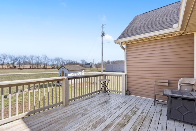 wooden terrace featuring a yard and an outbuilding