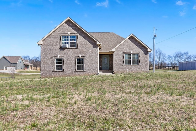 view of front facade with brick siding and a front yard