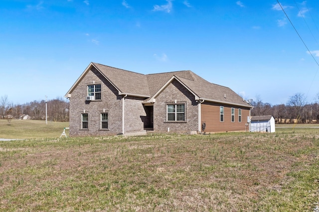 view of front of home with brick siding, a shingled roof, and a front lawn