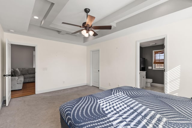 bedroom with a raised ceiling, ensuite bath, recessed lighting, carpet flooring, and baseboards