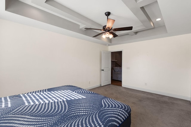 carpeted bedroom featuring ceiling fan, a raised ceiling, and baseboards