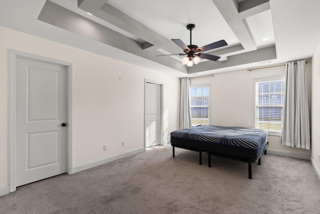 bedroom featuring a raised ceiling, carpet flooring, a ceiling fan, and baseboards