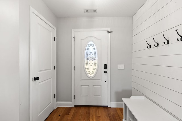 entrance foyer featuring visible vents, baseboards, wooden walls, and dark wood-style flooring