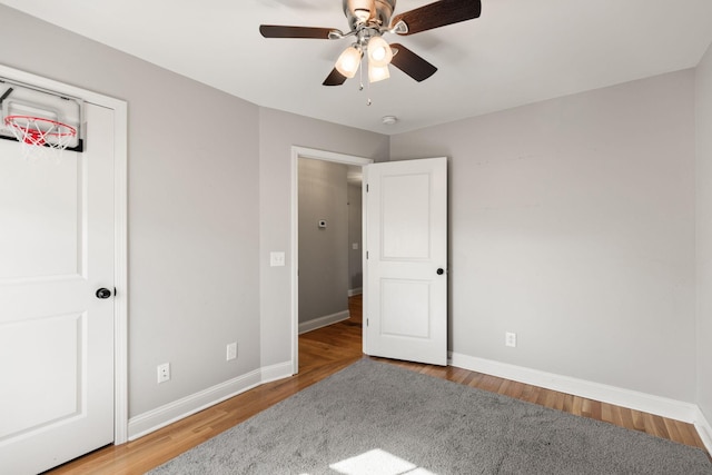 bedroom featuring ceiling fan, baseboards, and wood finished floors