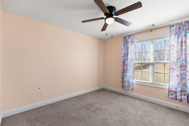 carpeted spare room with plenty of natural light, visible vents, baseboards, and ceiling fan