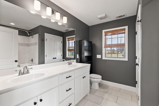 full bath with a sink, visible vents, toilet, and double vanity