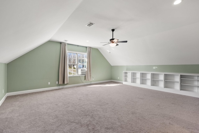 additional living space with visible vents, baseboards, ceiling fan, and vaulted ceiling