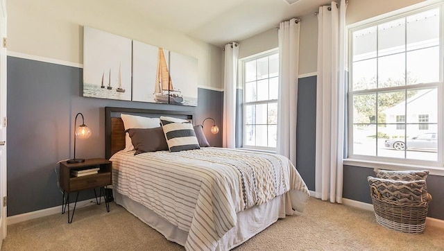 bedroom with light colored carpet and baseboards