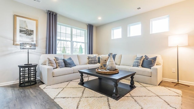 living area with visible vents, recessed lighting, baseboards, and wood finished floors