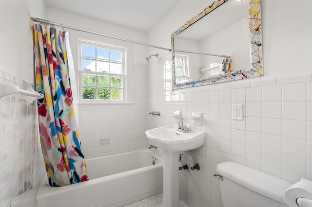 bathroom featuring tile walls, shower / tub combo, and toilet