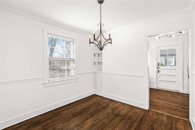 unfurnished dining area featuring crown molding, baseboards, and dark wood-type flooring