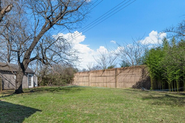 view of yard featuring an outdoor structure and fence