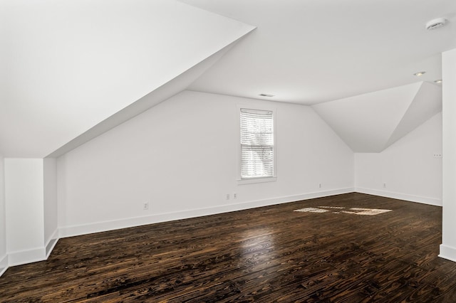 bonus room with visible vents, baseboards, wood finished floors, and vaulted ceiling