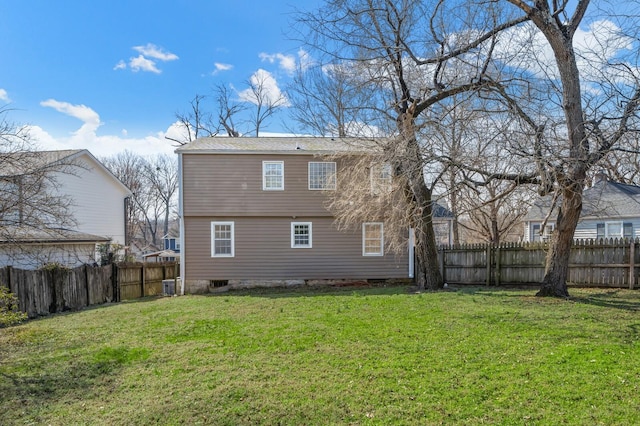 rear view of house featuring a fenced backyard and a yard