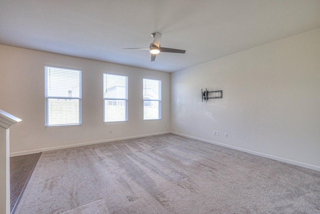 empty room with baseboards, ceiling fan, and carpet flooring