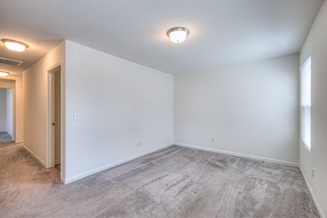 empty room featuring visible vents, baseboards, and carpet floors