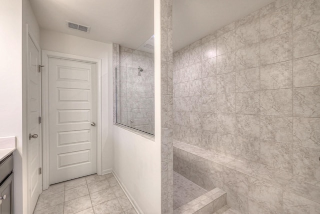 bathroom with visible vents, baseboards, vanity, and a walk in shower