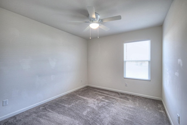 carpeted spare room with baseboards and a ceiling fan