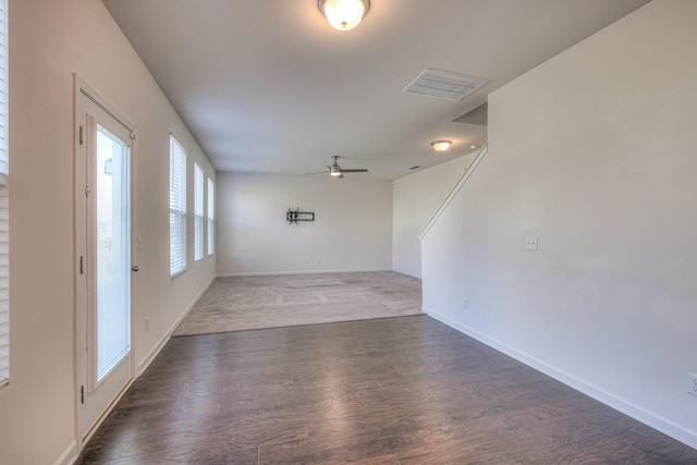 unfurnished room featuring ceiling fan, wood finished floors, visible vents, and baseboards