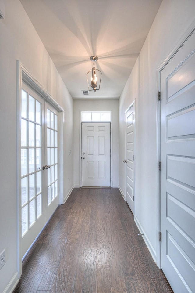 doorway featuring dark wood-style floors, baseboards, visible vents, an inviting chandelier, and french doors