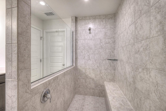 full bathroom featuring recessed lighting, visible vents, and a tile shower