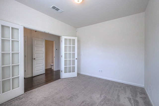 carpeted empty room with baseboards, visible vents, and french doors