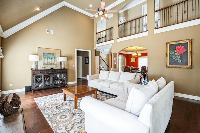 living room with baseboards, arched walkways, wood-type flooring, and ornamental molding