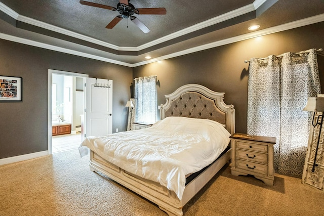 carpeted bedroom with a tray ceiling, baseboards, and ornamental molding