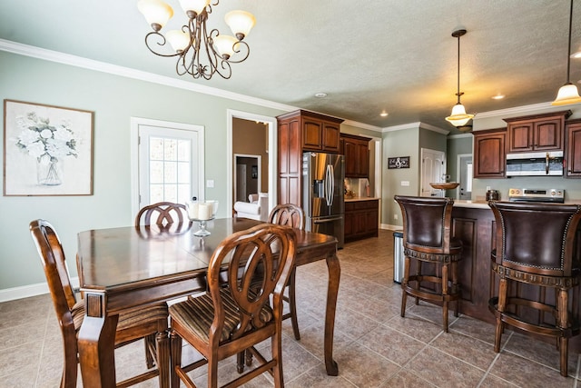 dining room with baseboards, a textured ceiling, ornamental molding, and tile patterned flooring