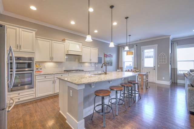 kitchen with a sink, stainless steel appliances, dark wood-style flooring, and white cabinetry