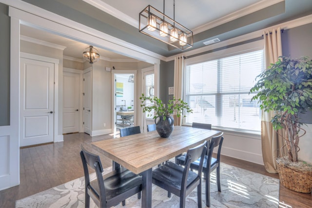 dining space with baseboards, a healthy amount of sunlight, wood finished floors, and crown molding