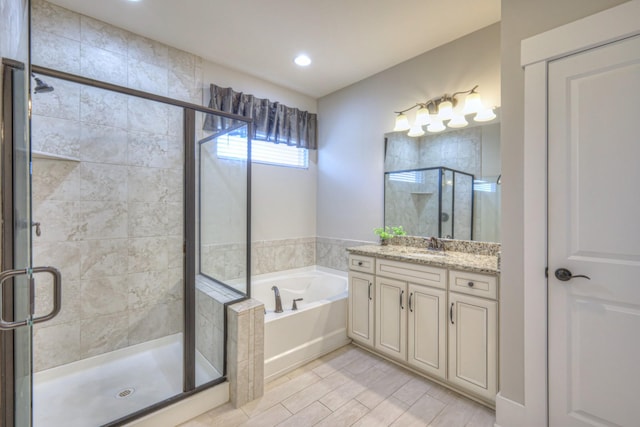 bathroom featuring vanity, a garden tub, wood finished floors, and a shower stall